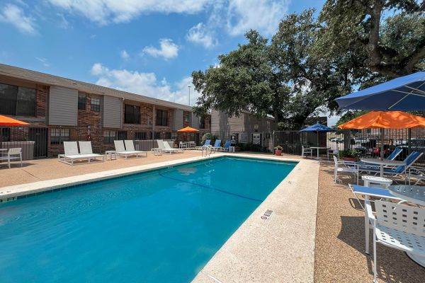 Autumn Chase apartment exterior featuring large pool with outdoor lounge