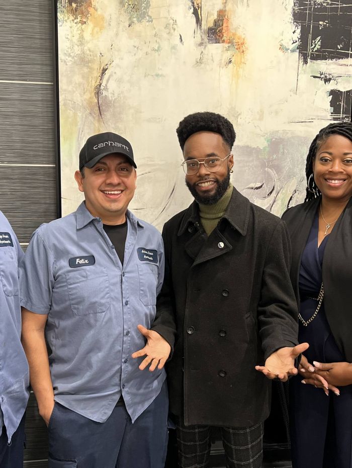 Four employees at Irwin R Rose gather by a large mural