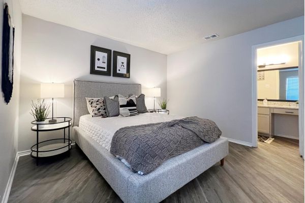 Ashwood Park apartment interior bedroom with wood plank flooring and furnished with large bed