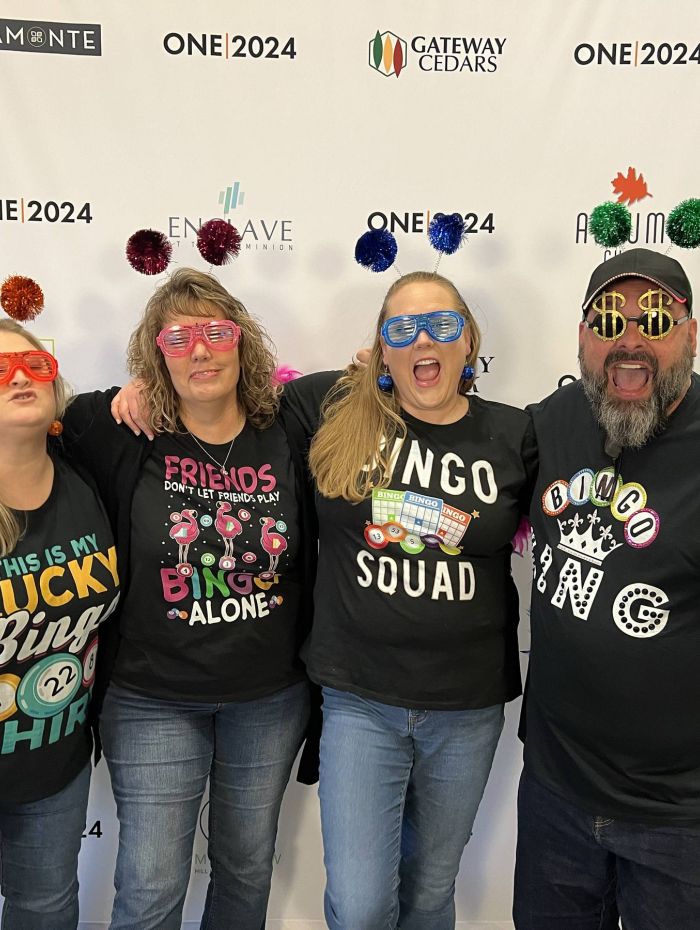 A group of Amalgamated employees at an event wearing fun glasses and colorful pom pom headbands