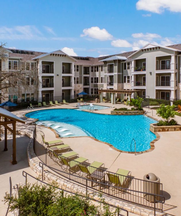 Enclave at the Dominion apartment exterior pool and lounge area with large swimming area and tanning deck