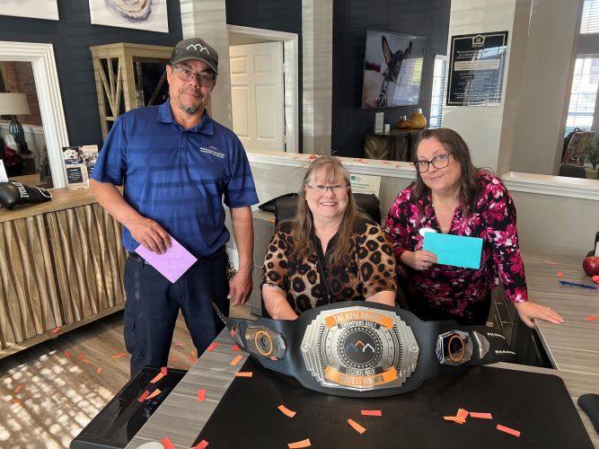 Irwin R Rose employees pose next to a huge weight belt