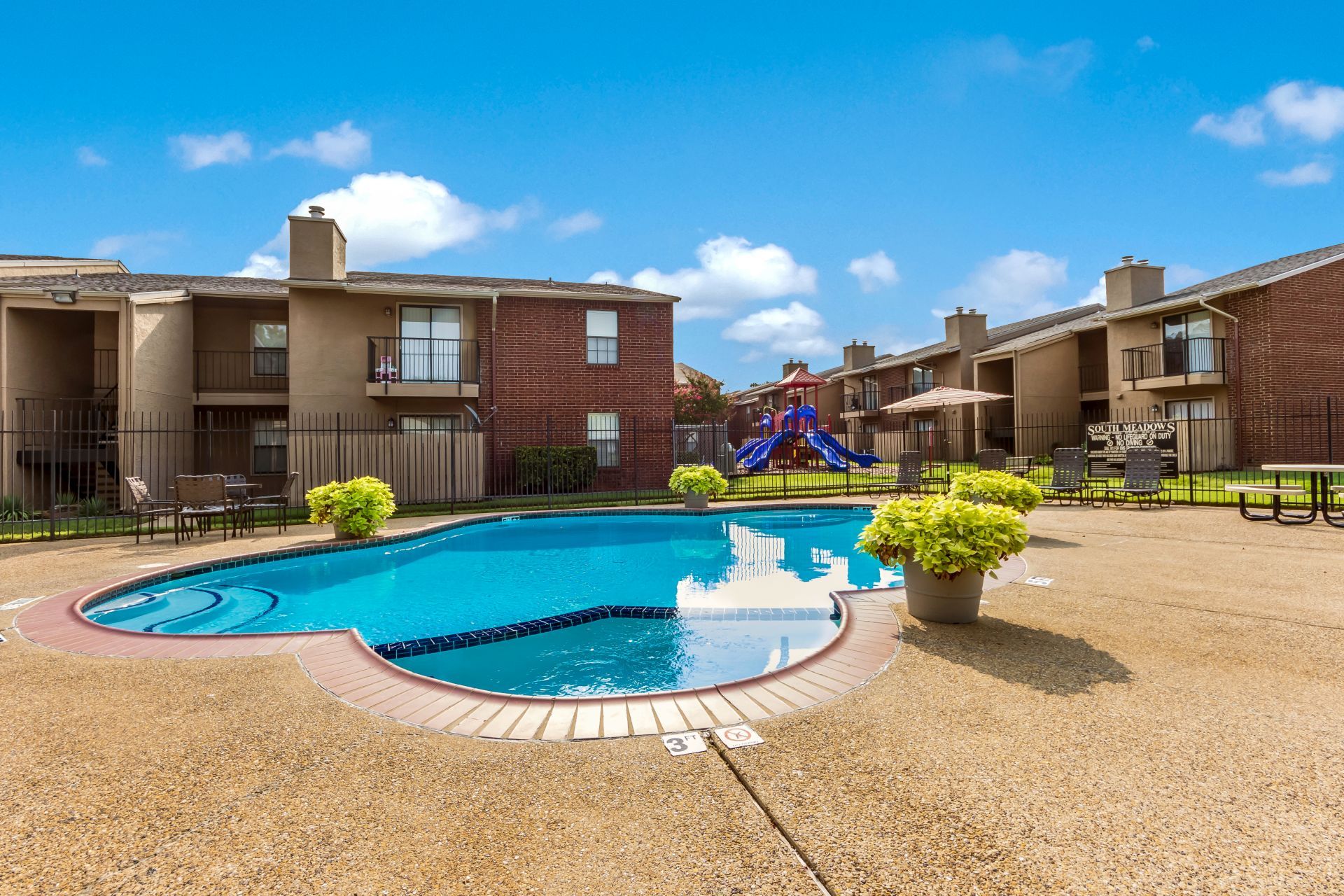 South Meadows Apartments property exterior featuring large community pool and sun deck