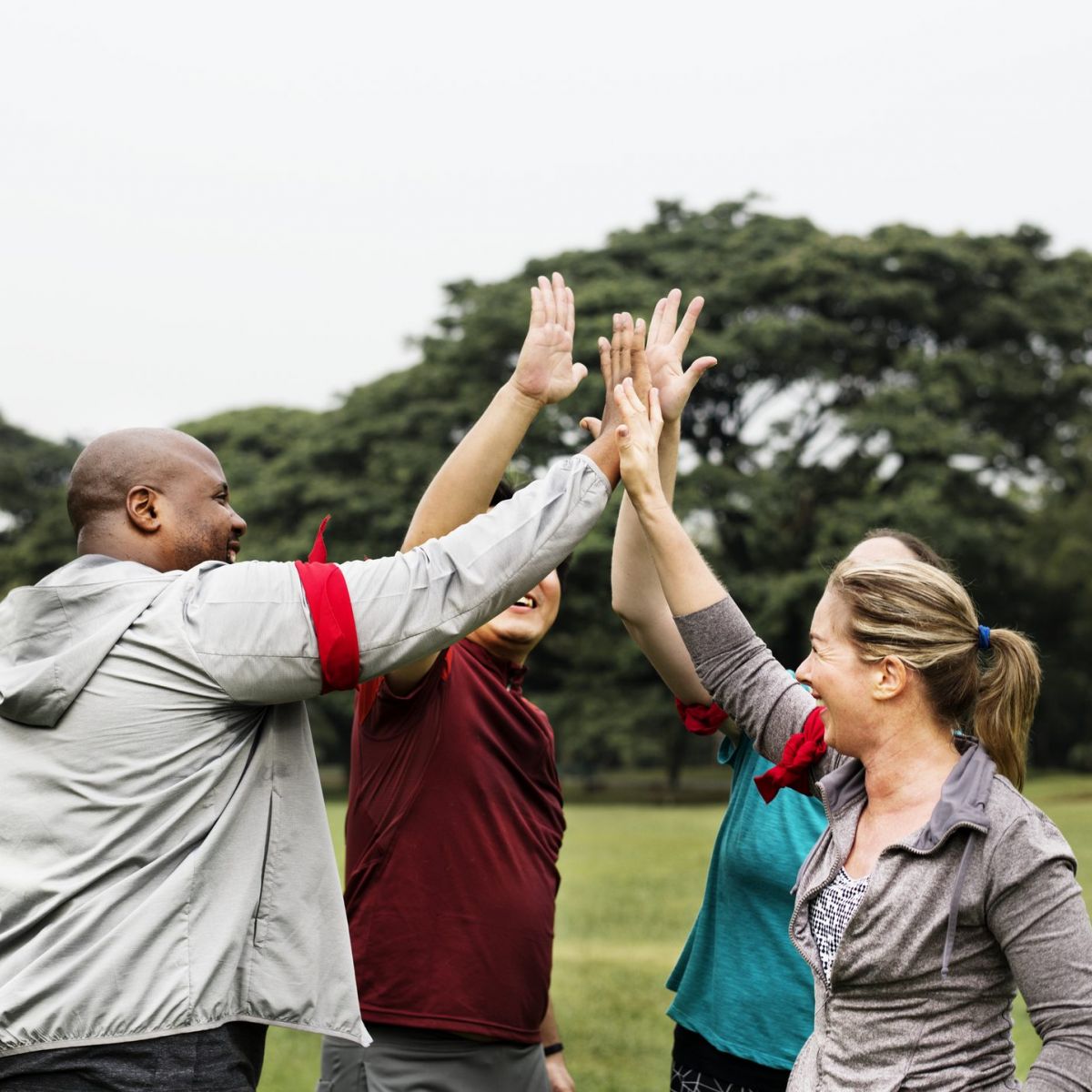 A group of people cheering and making a high five outside