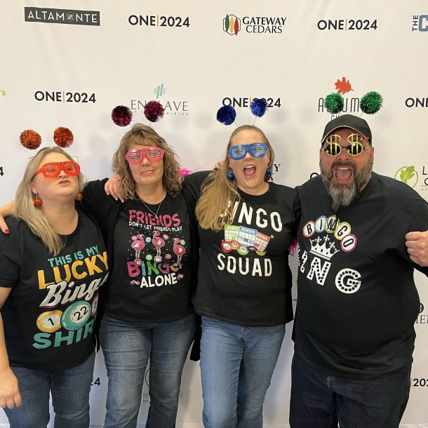 Irwin R. Rose team members pose at an event wearing silly glasses and pompom headbands