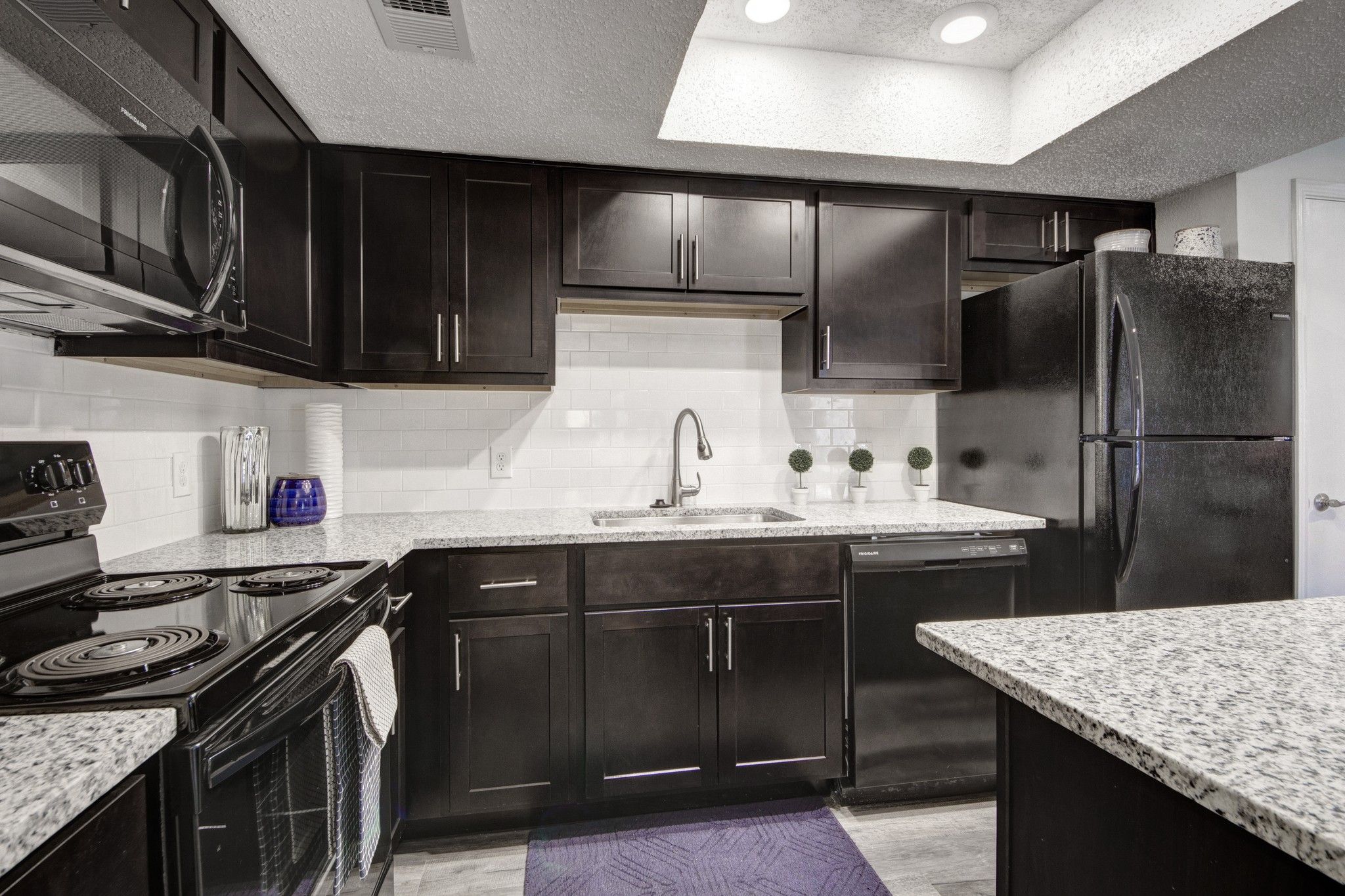 Crossings on Marsh apartment kitchen with granite countertops and wood cabinets
