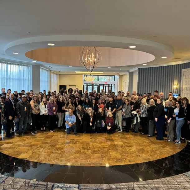 Irwin R. Rose company team portrait of large group in grand ballroom setting