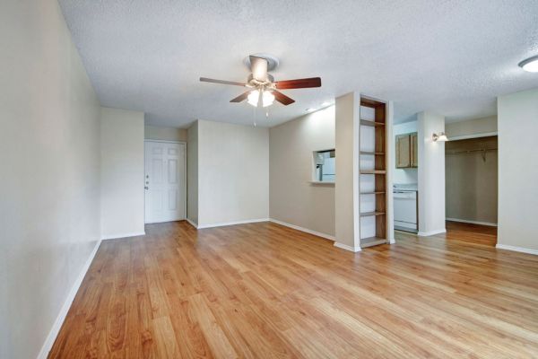 Quail Crossing apartment interior with wood floors, ceiling fan, and built-in bookcases